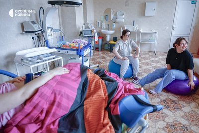 Оля і Оля сидять на кольорових фітболах у родзалі й чекають, коли знадобиться їхня допомога Оля і Оля сидять на кольорових фітболах у родзалі й чекають, коли знадобиться їхня допомога