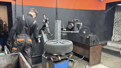 Працівник шиномонтажу на спеціальному верстаті накачує або перевіряє тиск у колесі. Миколаїв, листопад 2025 року Працівник шиномонтажу на спеціальному верстаті накачує або перевіряє тиск у колесі. Миколаїв, листопад 2025 року
