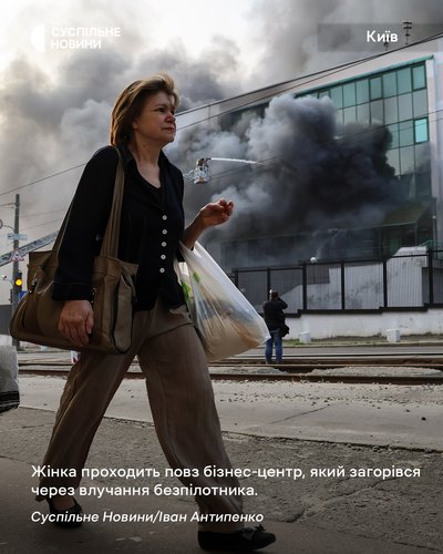 Жінка проходить повз бізнес-центр у Києві, який загорівся через влучання безпілотника Жінка проходить повз бізнес-центр у Києві, який загорівся через влучання безпілотника