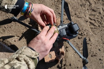 Бійці 40 ОБрБО кріплять навчальну гранату на дрон під час тренувань на півдні Бійці 40 ОБрБО кріплять навчальну гранату на дрон під час тренувань на півдні