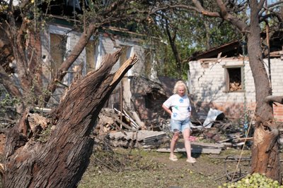 Жінка на своєму подвір'ї після обстрілу Ізюма Жінка на своєму подвір'ї після обстрілу Ізюма