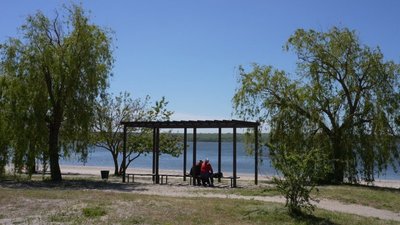 Люди сидять на лавках на пляжі у Миколаєві, 1 травня 2024 року