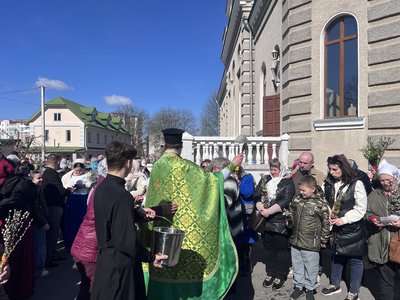 Священник Свято-Покровського собору поливає людей водою під час освячення вербового гілля