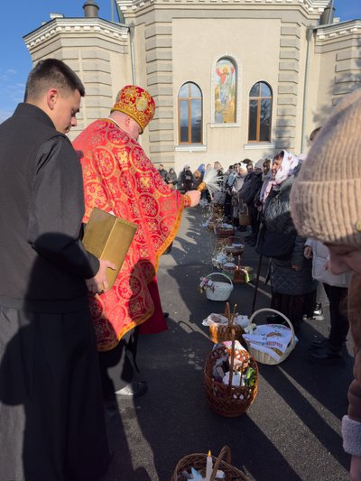 Священник освячує святою водою кошики Священник освячує святою водою кошики
