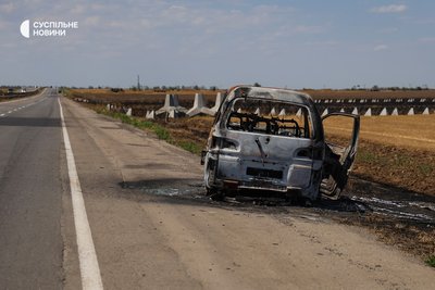 Автівка на трасі Миколаїв — Херсон, спалена російським FPV-дроном, липень 2025 року Автівка на трасі Миколаїв — Херсон, спалена російським FPV-дроном, липень 2025 року