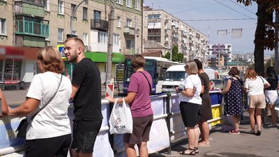 Чоловіки та жінки тримають прапор рідного, який у полоні або зник Чоловіки та жінки тримають прапор рідного, який у полоні або зник
