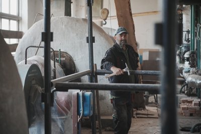 Працівник Ізюмського комунального підприємства тепломережі робить ремонт котельні в Ізюмі, липень 2025 року Працівник Ізюмського комунального підприємства тепломережі робить ремонт котельні в Ізюмі, липень 2025 року