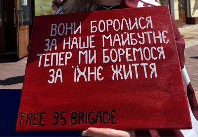 Учасниця акції тримає плакат Учасниця акції тримає плакат