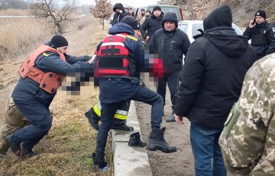 Рятувальники несуть тіло хлопчика Рятувальники несуть тіло хлопчика