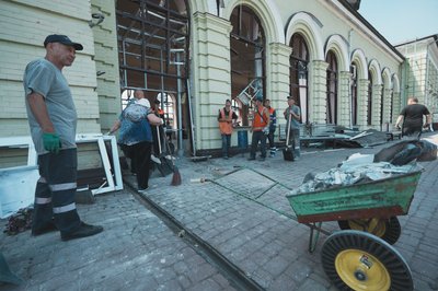 Люди прибирають після удару по Лозовій