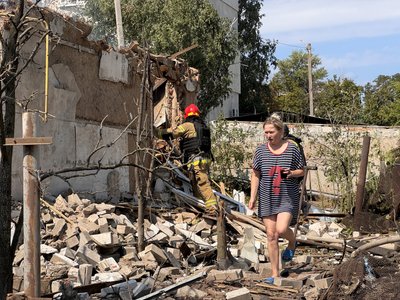 Жінка біля зруйнованого будинку в Балаклії Жінка біля зруйнованого будинку в Балаклії