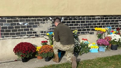 Військовий покладає квіти до муралу Військовий покладає квіти до муралу