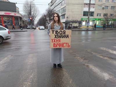 Волонтерка стоїть з плакатом Волонтерка стоїть з плакатом