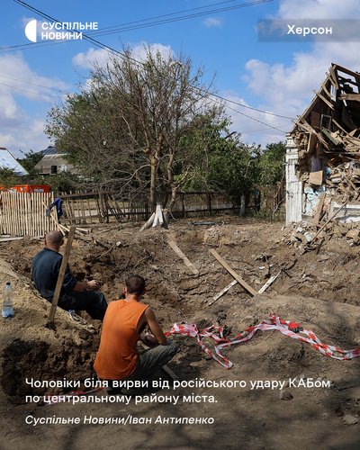 Чоловіки біля вирви від російського удару КАБом по центральному району Херсона Чоловіки біля вирви від російського удару КАБом по центральному району Херсона