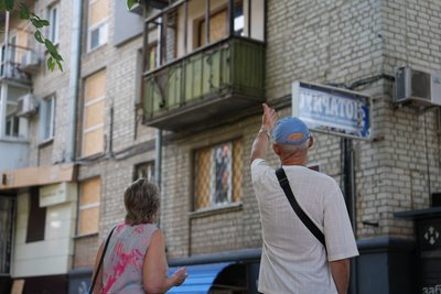 Жителі Харкова дивляться на багатоповерхівку, яка була пошкоджена через влучання російського безпілотника вночі 12 липня 2026 року Жителі Харкова дивляться на багатоповерхівку, яка була пошкоджена через влучання російського безпілотника вночі 12 липня 2026 року