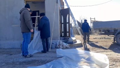 Місцеві жителі плівкою закривають вибиті вікна Місцеві жителі плівкою закривають вибиті вікна