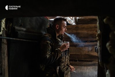 військовий відпочиває біля входу у бліндаж, Часів Яр, Донеччина, липень 2024 року