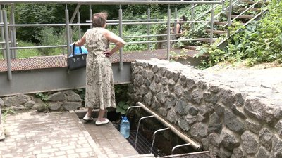 Жінка набирає воду в Харкові