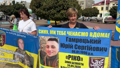 Учасники акції тримають прапори та плакати із зображеннями своїх рідних