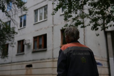 Комунальник оглядає пошкодження на будинку Комунальник оглядає пошкодження на будинку