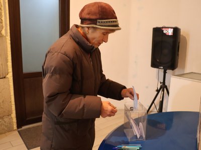 Жінка віддає свій голос за творчу роботу, представлену на виставці у храмі Миколаєва Жінка віддає свій голос за творчу роботу, представлену на виставці у храмі Миколаєва