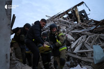 Рятувальники виносять поранену жінку, яку вони діставали з-під завалів у Херсоні Рятувальники виносять поранену жінку, яку вони діставали з-під завалів у Херсоні