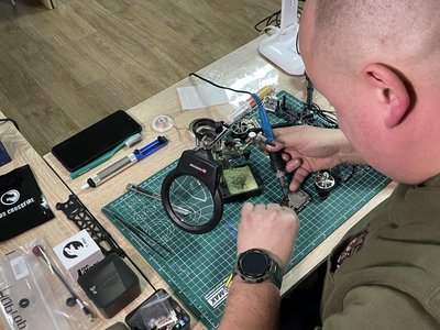 Волонтер Сергій Савіцький паяє запчастину для дрона Волонтер Сергій Савіцький паяє запчастину для дрона