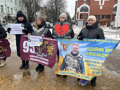 Рідні полонених та зниклих безвісти тримають прапори та плакати Рідні полонених та зниклих безвісти тримають прапори та плакати