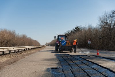 Дорожник працює на трасі М03 у Харківській області Дорожник працює на трасі М03 у Харківській області