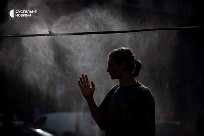 дівчина підставляє руку під краплі води біля рамки-розпилювача на Хрещатику у Києві, 12 липня 2024 року дівчина підставляє руку під краплі води біля рамки-розпилювача на Хрещатику у Києві, 12 липня 2024 року