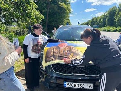 Люди розміщають на авто прапор загиблого