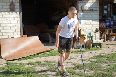 Хлопчик ходить з палицею по своєму двору Хлопчик ходить з палицею по своєму двору