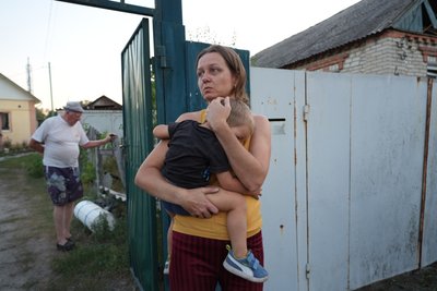 Матір тримає дитину на руках після російського удару Матір тримає дитину на руках після російського удару