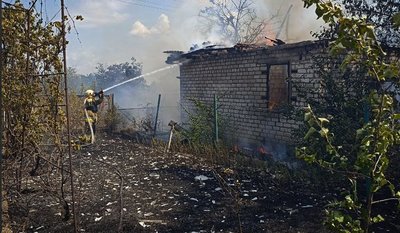 Рятувальник ДСНС гасить пожежу на будинку Рятувальник ДСНС гасить пожежу на будинку