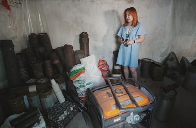Жінка в підвалі біля воєнних артефактів Жінка в підвалі біля воєнних артефактів