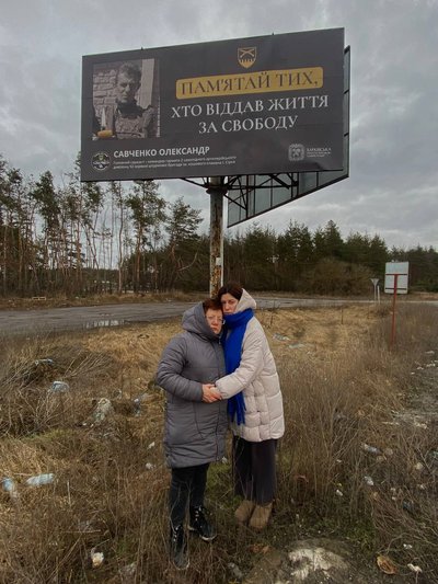 Жінки біля бігборда з загиблим військовим Жінки біля бігборда з загиблим військовим