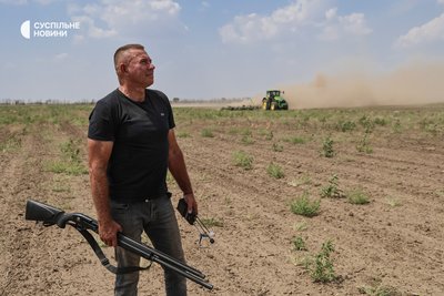 Фермер з Бериславщини Олександр Гордієнко у полі з антидроновою рушницею "прикриває" небо, поки його співробітники працюють трактором у полі. Херсонщина, липень 2025 року Фермер з Бериславщини Олександр Гордієнко у полі з антидроновою рушницею "прикриває" небо, поки його співробітники працюють трактором у полі. Херсонщина, липень 2025 року