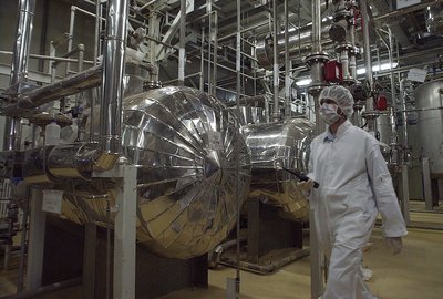 Іранський співробітник служби безпеки в захисному одязі проходить частиною заводу з переробки урану недалеко від іранського міста Ісфахан, 30 березня 2005 року Іранський співробітник служби безпеки в захисному одязі проходить частиною заводу з переробки урану недалеко від іранського міста Ісфахан, 30 березня 2005 року