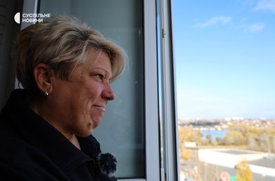 Тетяна Кравець дивиться з вікна будинку у Корабельному районі у Херсоні 18 листопада 2024 року Тетяна Кравець дивиться з вікна будинку у Корабельному районі у Херсоні 18 листопада 2024 року