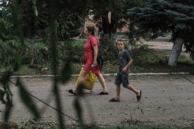 Жінка та хлопчик йдуть вулицею Жінка та хлопчик йдуть вулицею