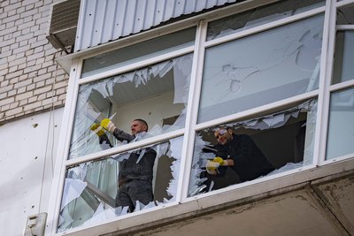 Чоловіки прибирають розбите скло на балконі житлового будинку у Дніпрі після обстрілу 27 березня 2025 року Чоловіки прибирають розбите скло на балконі житлового будинку у Дніпрі після обстрілу 27 березня 2025 року
