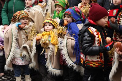 Діти їдять пампухи на церемонії встановлення різдвяного дідуха у Львові, 24 грудня 2023