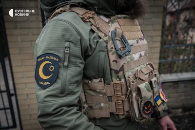Шеврон на правому рукаві куртки у Хаджи Мурада – офіційна нашивка капеланської служби мусульман України, Донеччина, грудень 2022 року. На його бронежилеті й інші шеврони, подаровані йому різними людьми за час служби капеланом. Шеврон на правому рукаві куртки у Хаджи Мурада – офіційна нашивка капеланської служби мусульман України, Донеччина, грудень 2022 року. На його бронежилеті й інші шеврони, подаровані йому різними людьми за час служби капеланом.