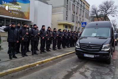 Поліцейські біля будівлі Міністерства внутрішніх справ України проводжають кортеж автомобілів з тілами керівників МВС, які загинули в авіакатастрофі у Броварах, Київ, 21 січня 2023 року.