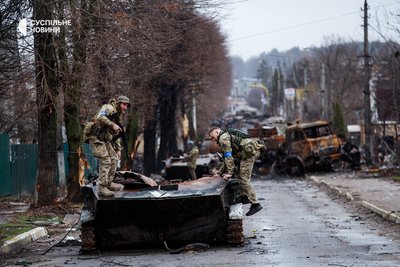 Українські бійці залізають на спалену російську техніку на одній з центральних вулиць у звільненій Бучі на Київщині, квітень 2022 року.