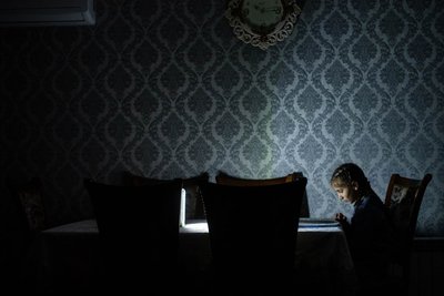 Школярка виконує домашнє завдання під час відключень світла в Ханкенді / Степанакерті Школярка виконує домашнє завдання під час відключень світла в Ханкенді / Степанакерті