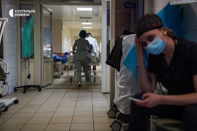 Лікар та медсестра перевозять з операційної до палати стаціонару військового, якому провели планову операцію, Київ, січень 2023 року.