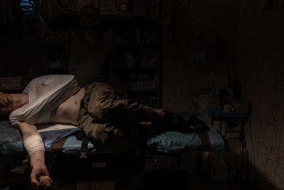 Поранений український військовий на ношах у стабпункті поблизу Бахмута Поранений український військовий на ношах у стабпункті поблизу Бахмута