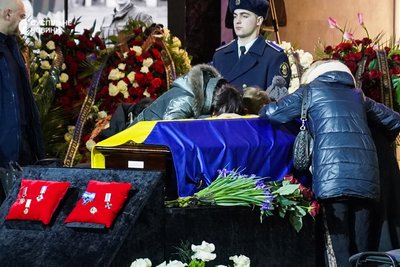 Сім'я першого заступника міністра внутрішніх справ Євгенія Єніна біля труни з його тілом під час церемонії прощання із загиблими в авіакатастрофі у Броварах, Український дім, Київ, 21 січня 2023 року.