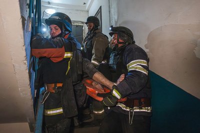 рятувальники несуть поранену, яку звільнили з-під завалів у Мирнограді, обстріл на Донеччині